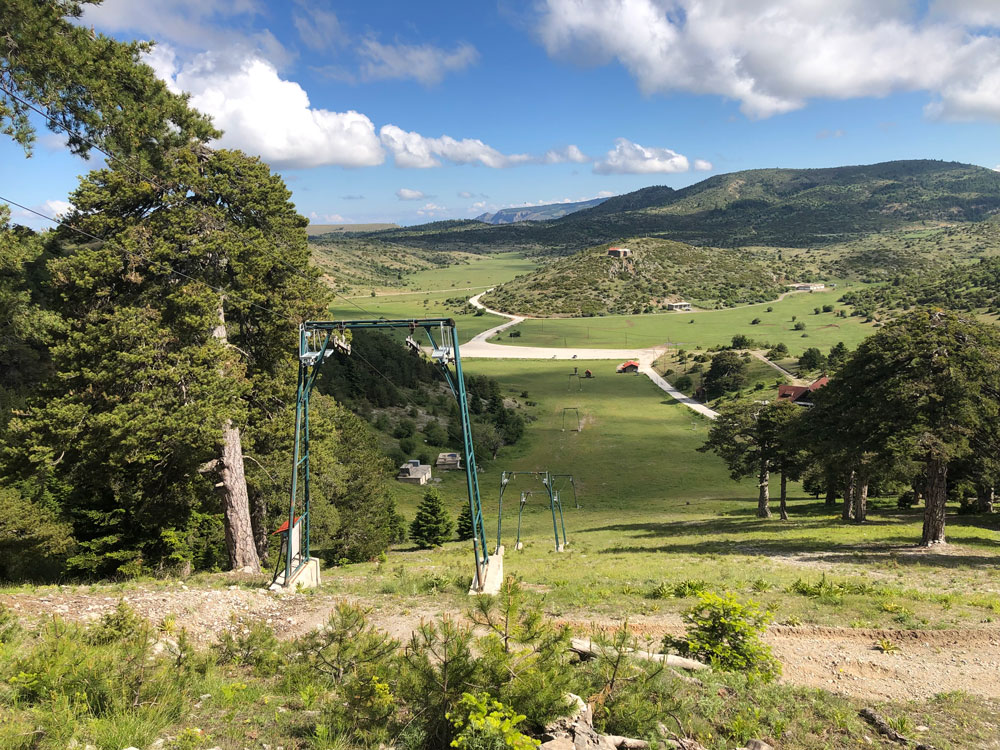 View of ski lift and mountain slopes looking down to ski car park.