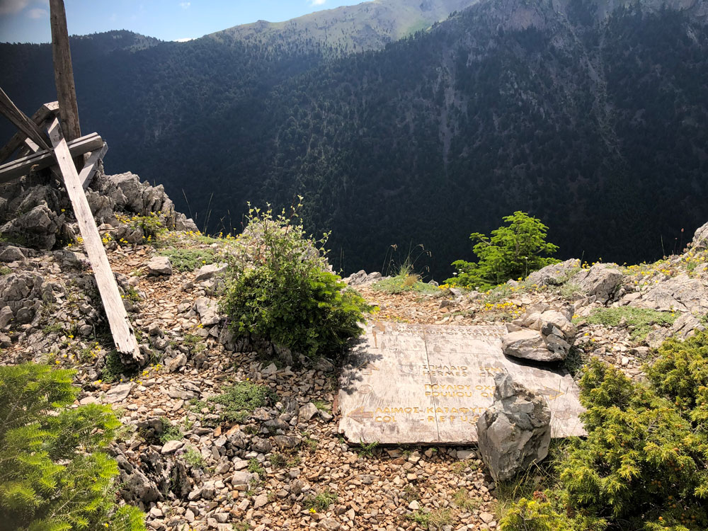 View of a broken signpost and mountain slopes in the background.