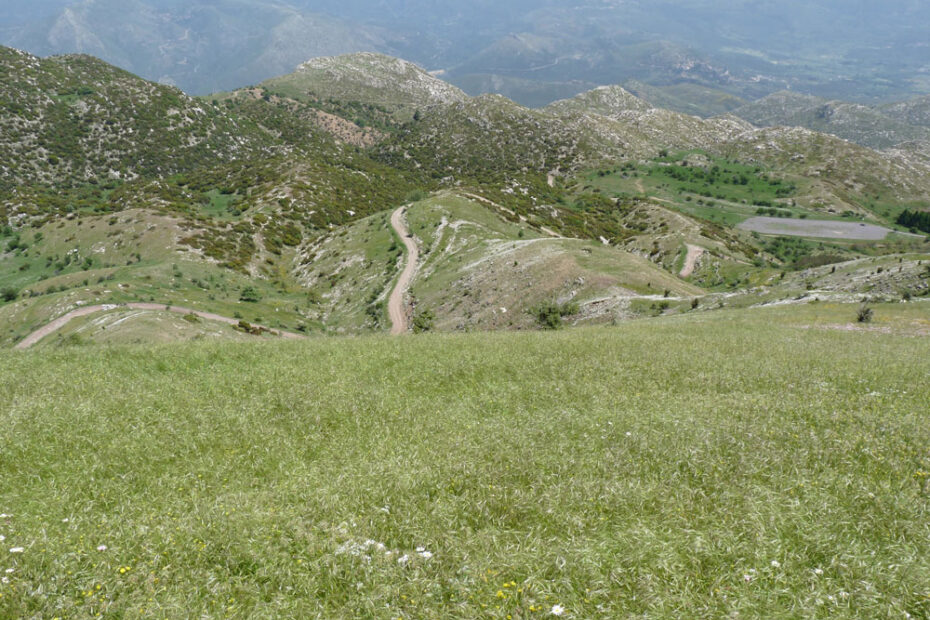 View from mountain summit, with path and ancient stadium in the distance.