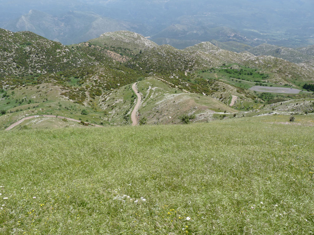 View from mountain summit, with path and ancient stadium in the distance.