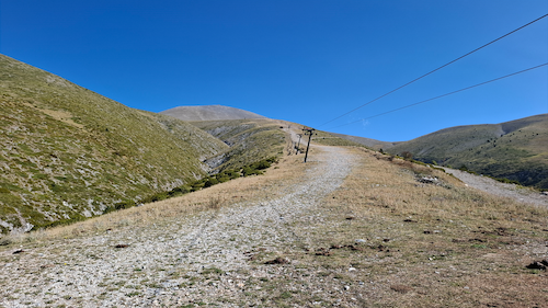 Rocky slope looking uphill next to ski lifts.