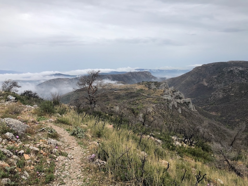 Rocky path with distant views of hills and mist.