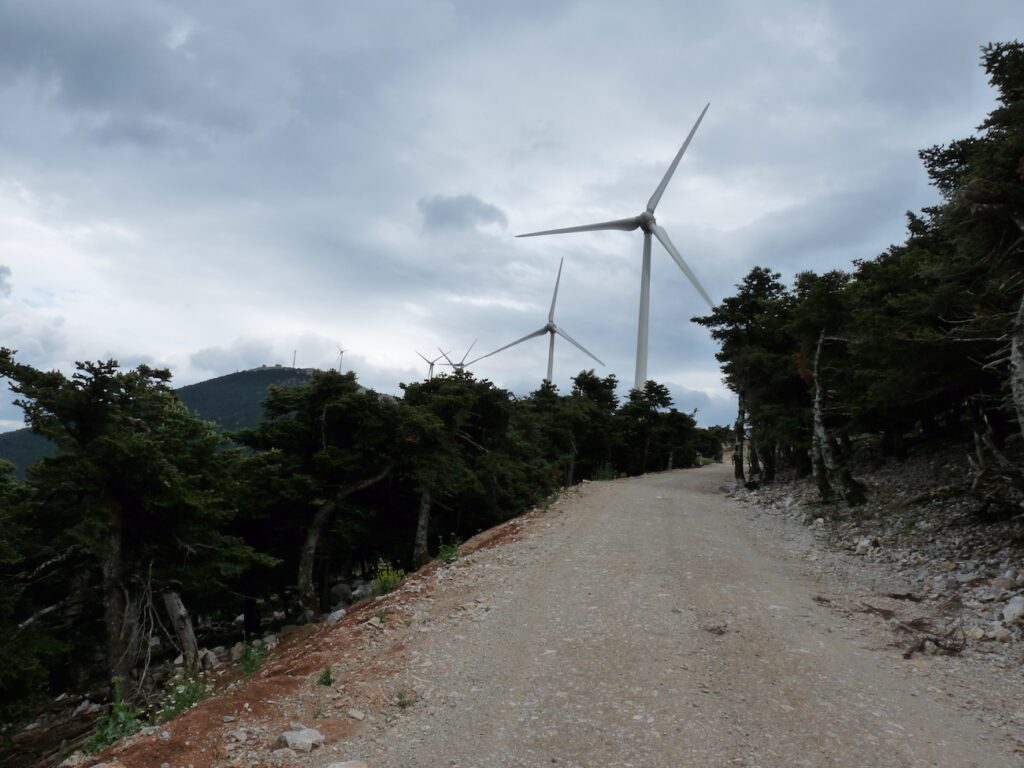 wide track with wind turbines and mountain summit in the distance