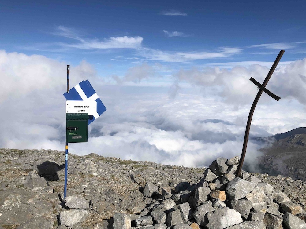 mountain summit with cross and signpost