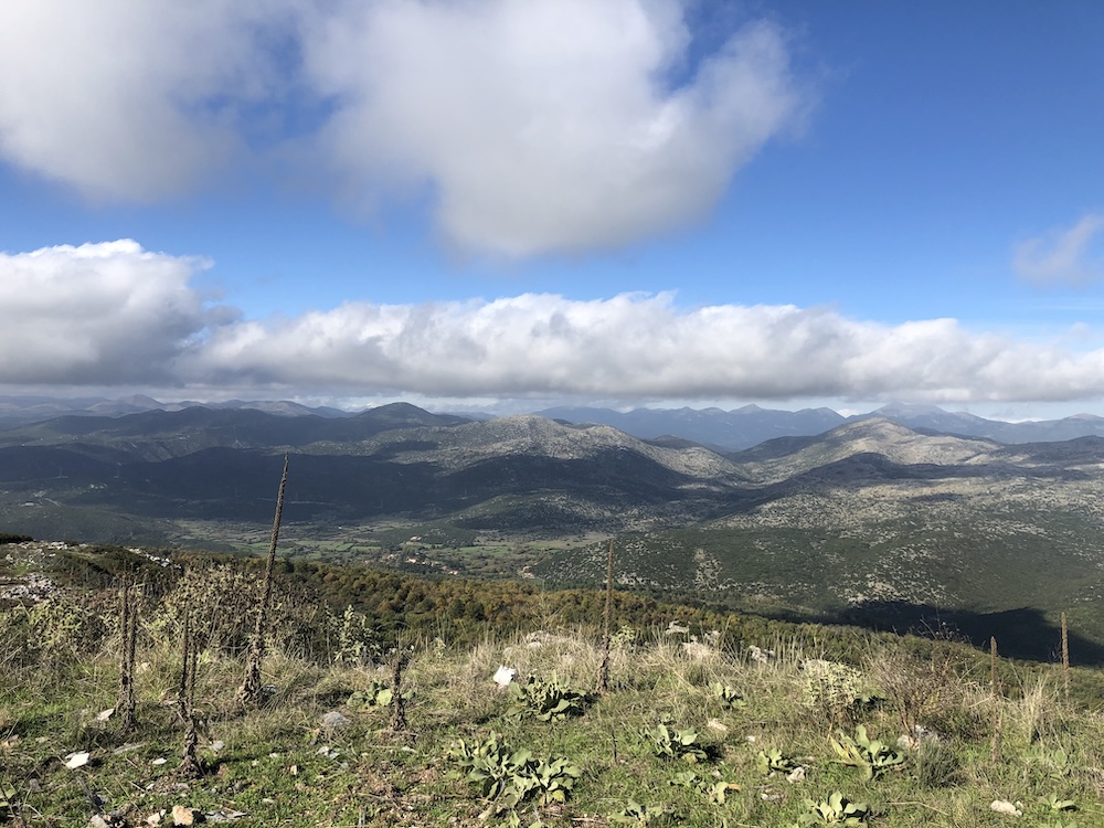 View of distant mountains, with blue sky and a layer of cloud above.