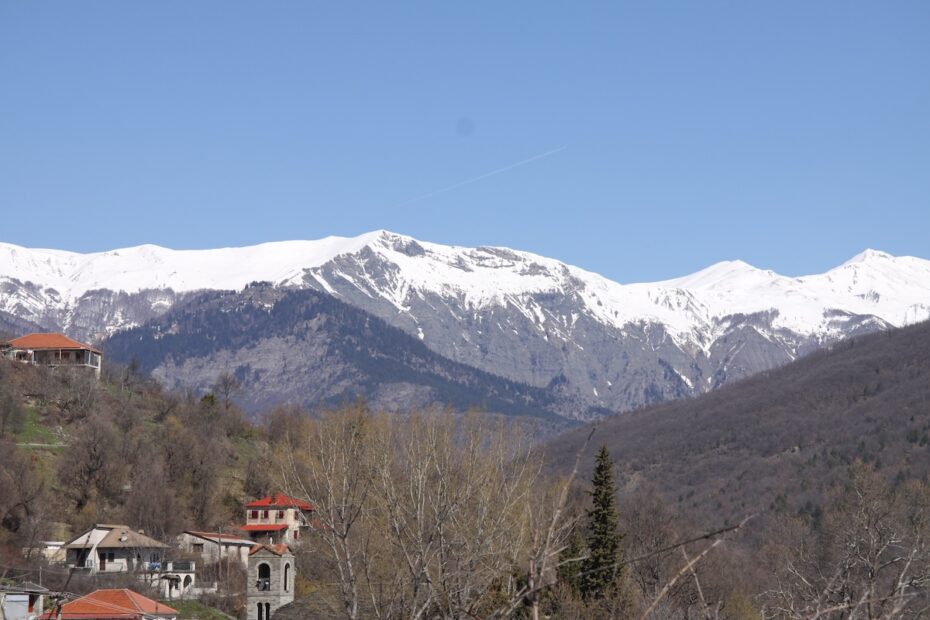 snow-covered mountains with buildings in foreground.
