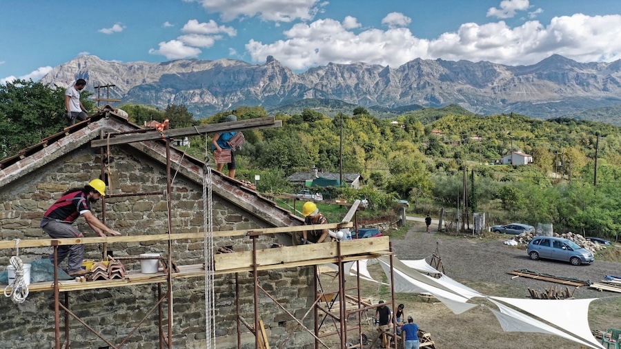 building work underway on scaffolding with mountains behind