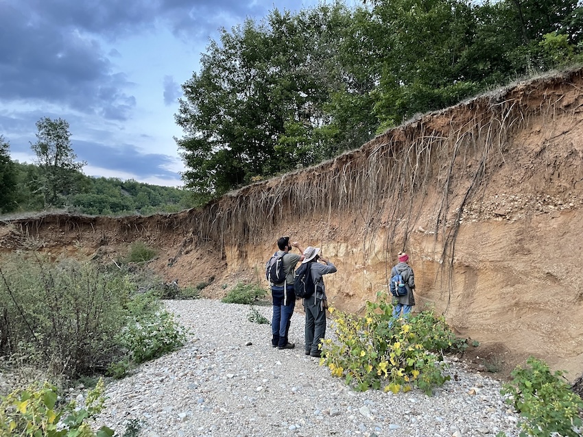 researchers inspecting eroded hillside.
